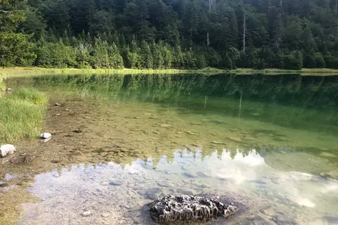Planinsko jezero sa odrazom oblaka